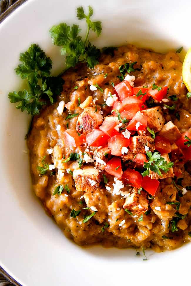 top view of creamy chicken risotto in a white bowl garnished with parrsley