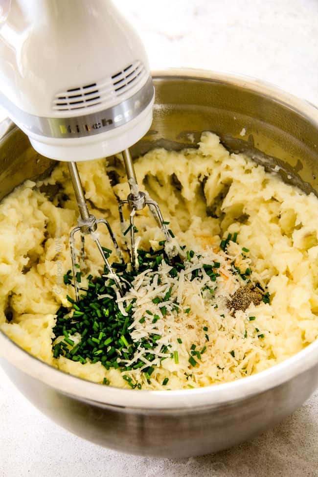 showing how to make mashed potato recipe by mixing potatoes in a bowl with butter and chives