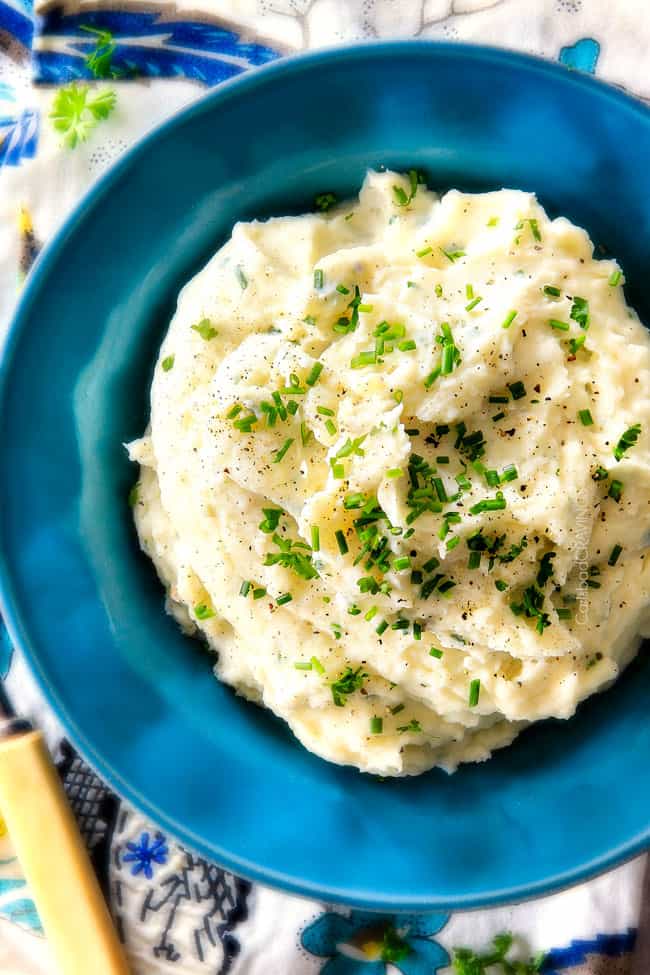 top  view of garlic mashed potatoes in a bowl showing how creamy they arer, garlic, and Parmesan! I could eat these all day alone with a spoon - they are incredibly velvety, flavorful and so good everyone will beg you for the recipe!