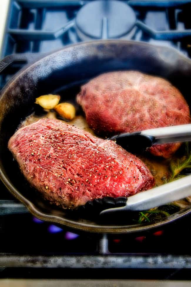 Showing how to make Pan Seared Steak cooking in a pan with herbs. 