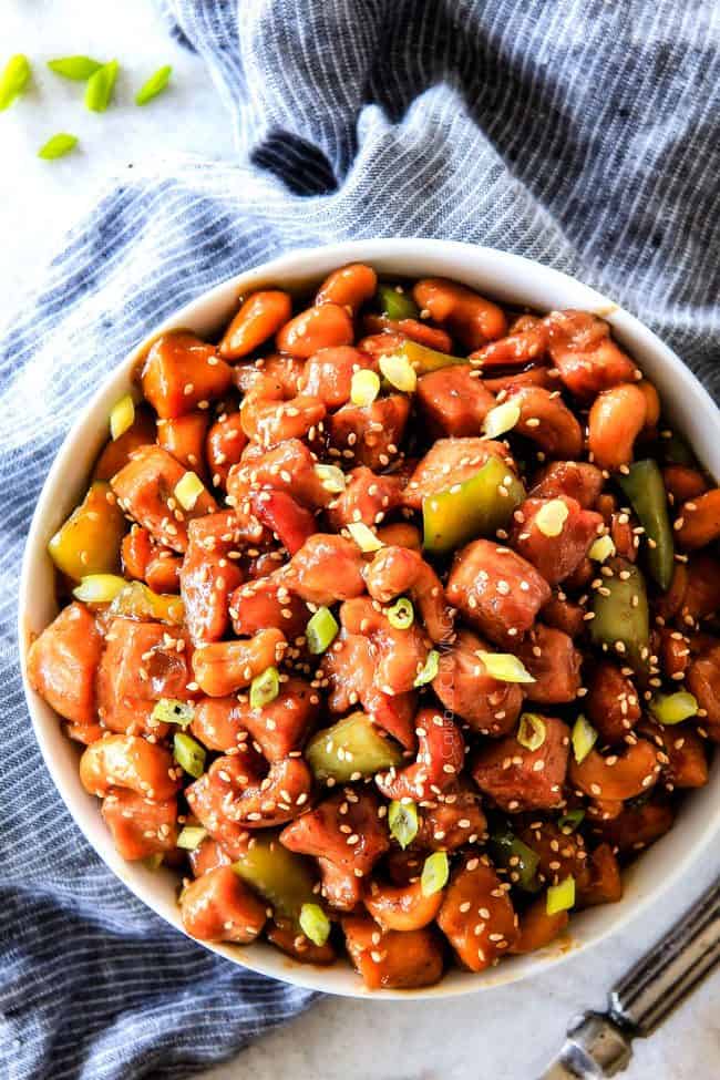 Top view of Crockpot Cashew Chicken garnished with sesame seeds in a white bowl