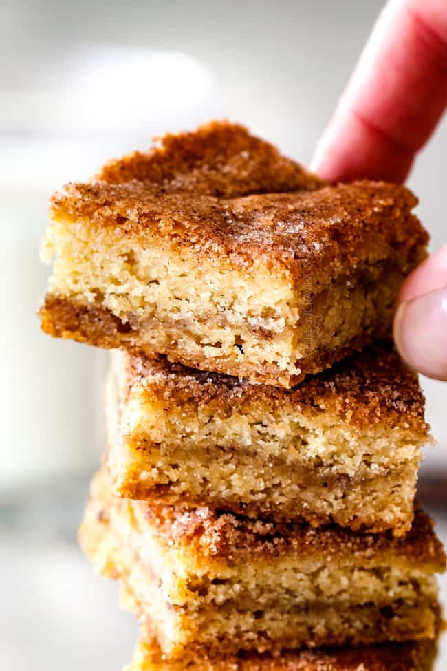 a hand picking up thick Snickerdoodle Bars