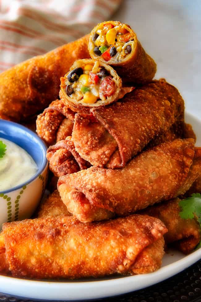 a stack of fried Southwest Egg Rolls on a plate with Cilantro Dip