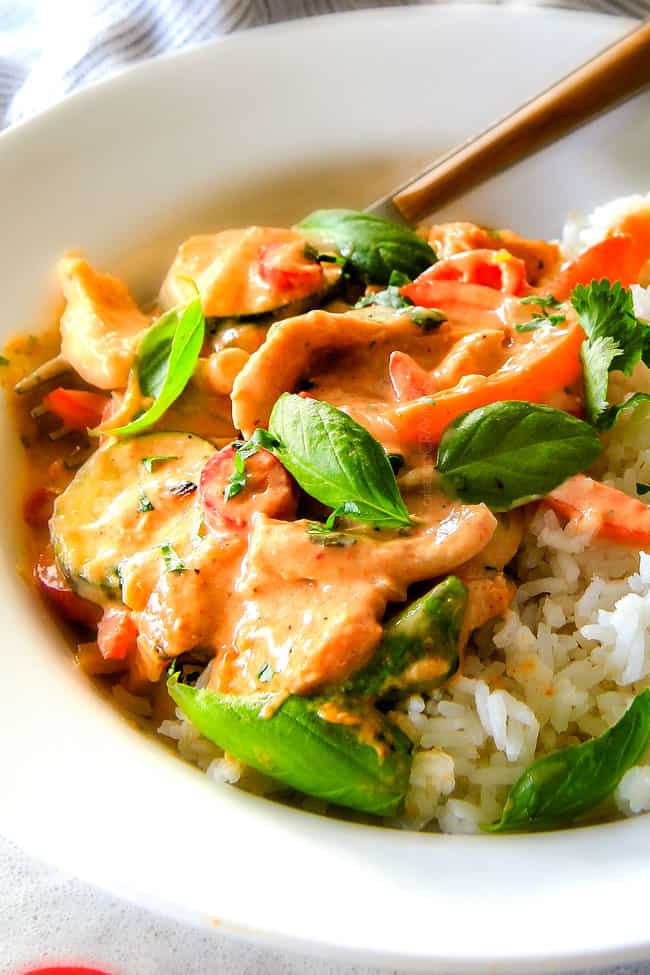 Close up of Thai Red Curry Chicken with rice and chop sticks.