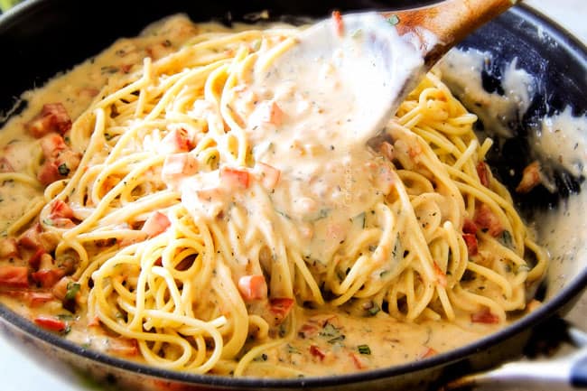 Stirring Garlic Mozzarella Margherita Pasta with basil. with a wood spoon. 