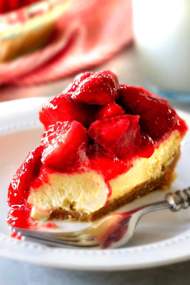 Strawberry Cheesecake with a bite missing next to a fork. 