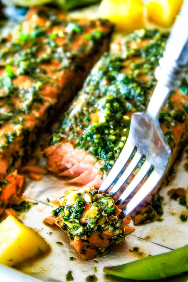 Asian Chimichurri Salmon on a pan with vegetables fork cutting a piece. 