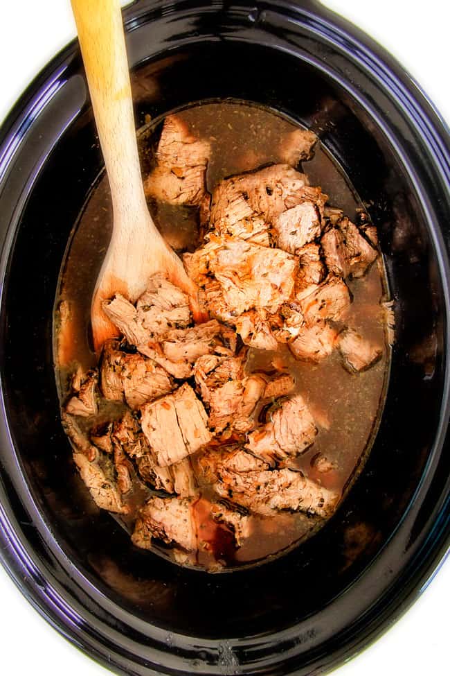 showing how tot make Italian Beef Sandwiches by adding sliced beef back to slow cooker