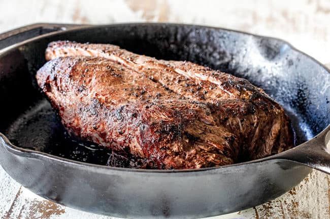 showing how to make Italian Beef Sandwiches by searing beef in a cast iron skillet