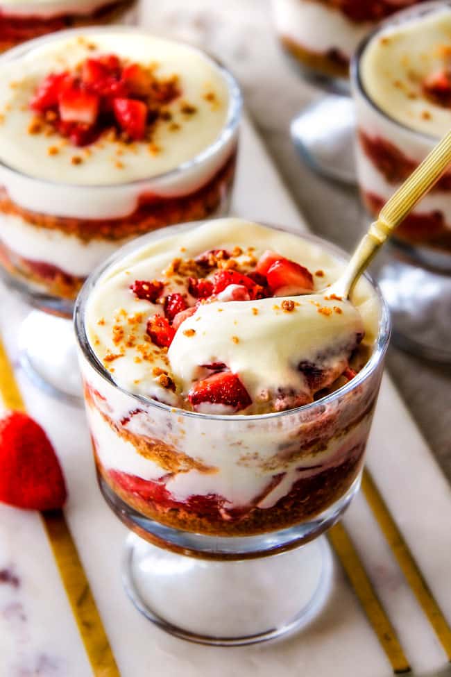 Strawberry Cheesecake Parfaits with a spoon taking a scoop. 