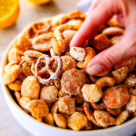 Everyone begs me to bring this seriously addicting Lemon Snack Mix to every party and get together!   Its super easy, make ahead,  sweet and tangy and coated in AMAZING White Chocolate Lemon Glaze!  Your friends will love it!