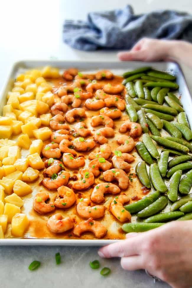 two hands holding a serving tray of easy teriyaki shrimp