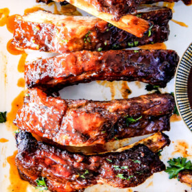 15 minute prep Fall-Off-the-Bone Slow Cooker HONEY BUFFALO Ribs that everyone goes crazy for!  These are SO tender and SO easy!  They are slathered in an amazing rub and the most addicting honey buffalo sauce ever!