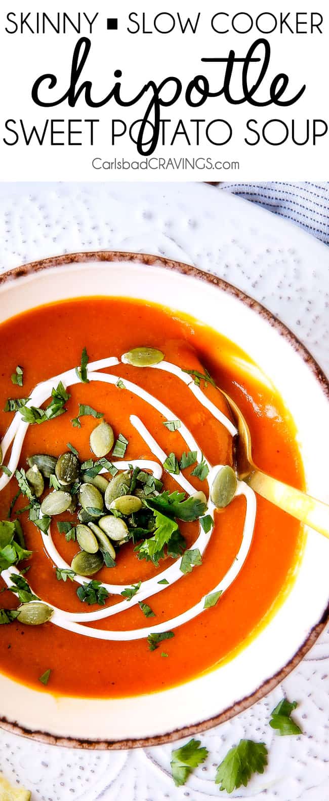 top view of savory sweet potato soup in a bowl garnished with pumpkin seeds and a swirl of cream