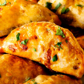 Freezer friendly, juicy, cheesy, shortcut Chipotle Chicken Empanadas doused in refreshingly Avocado Dip make the BEST crowd pleasing appetizers, dinners or snacks and can be made ahead of time and frozen for later!  The filling is to die for and the store bought puff pastry dough makes an easy shortcut for the buttery, flaky golden pastry!