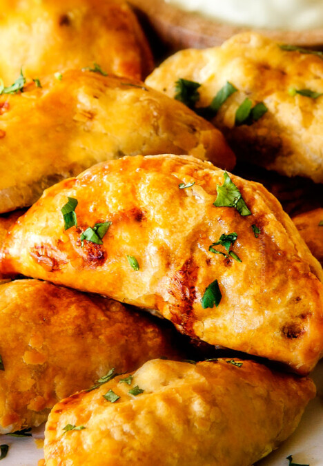 Freezer friendly, juicy, cheesy, shortcut Chipotle Chicken Empanadas doused in refreshingly Avocado Dip make the BEST crowd pleasing appetizers, dinners or snacks and can be made ahead of time and frozen for later!  The filling is to die for and the store bought puff pastry dough makes an easy shortcut for the buttery, flaky golden pastry!
