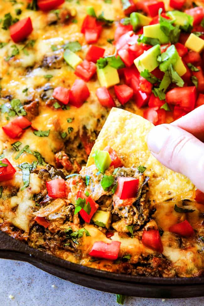 Cheesy Mexican Spinach Dip with chip and avocado and tomato. 