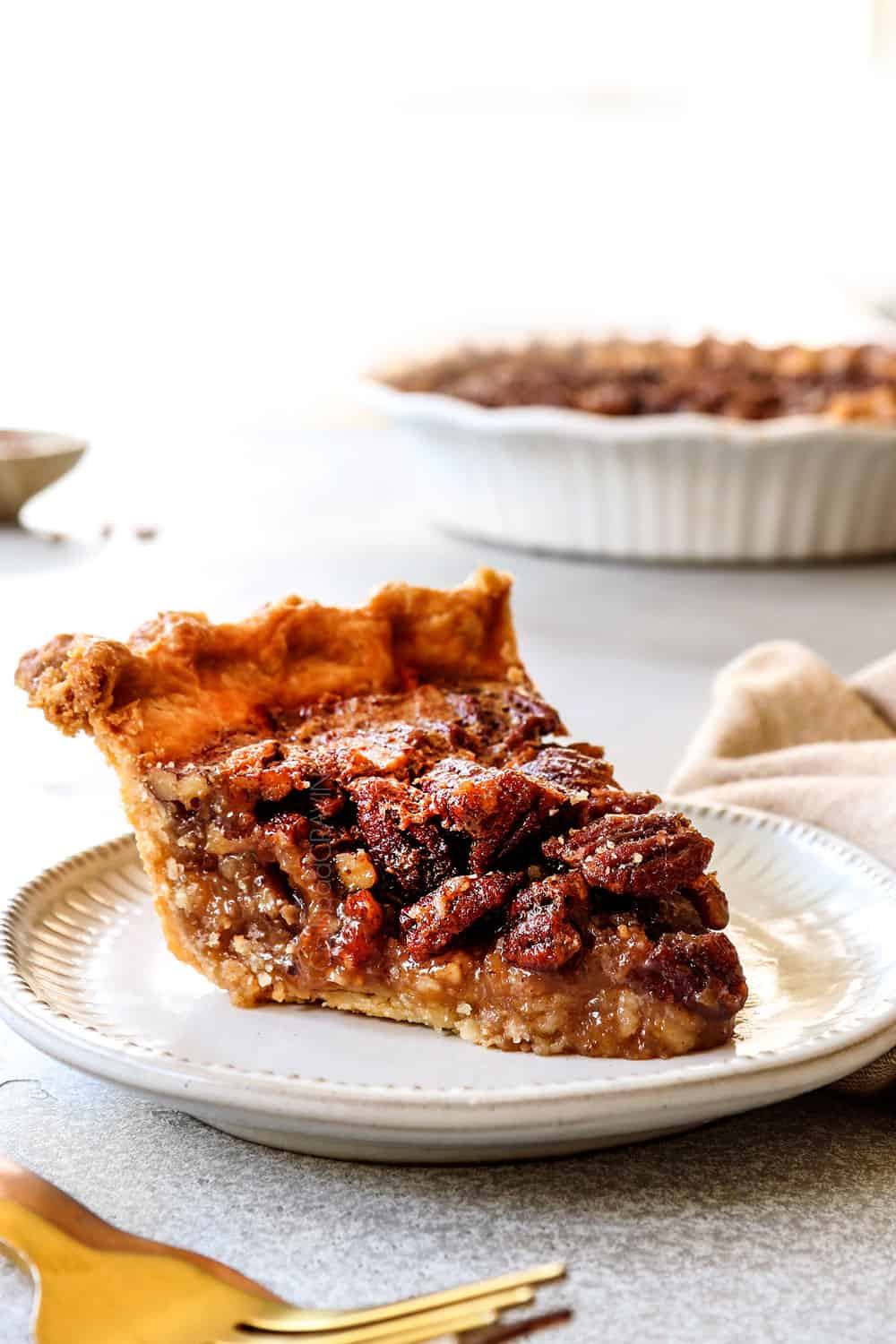side view of homemade pecan pie on a plate showing the custard texture