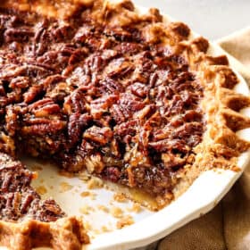 up close side view of pecan pie recipe in the pie plate with a piece missing showing the texture if the filling
