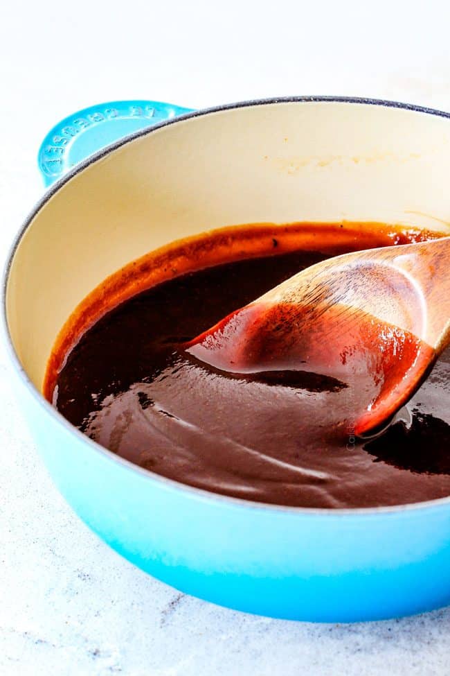 showing how to make barbecue sauce recipe by stirring the sauce while it simmers in a teal saucepan