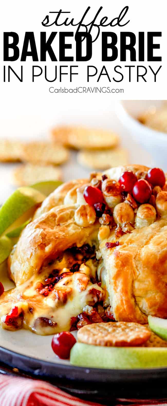 baked brie in puff pastry with with jam and cranberries oozing out of center