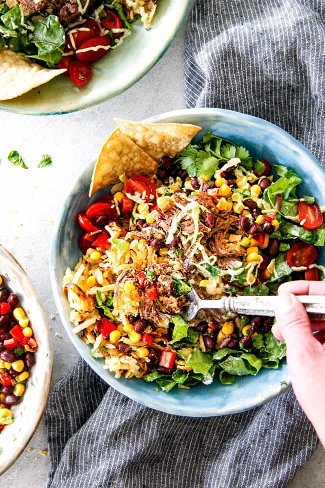 Barbacoa Beef Taco Bowls with Hash Browns & Avocado Ranch with a fork taking a bite.