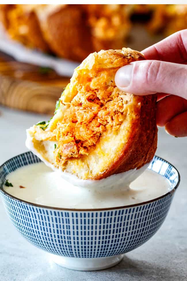 up close of dunking a piece of Buffalo Chicken Pull Apart Bread into blue cheese dressing