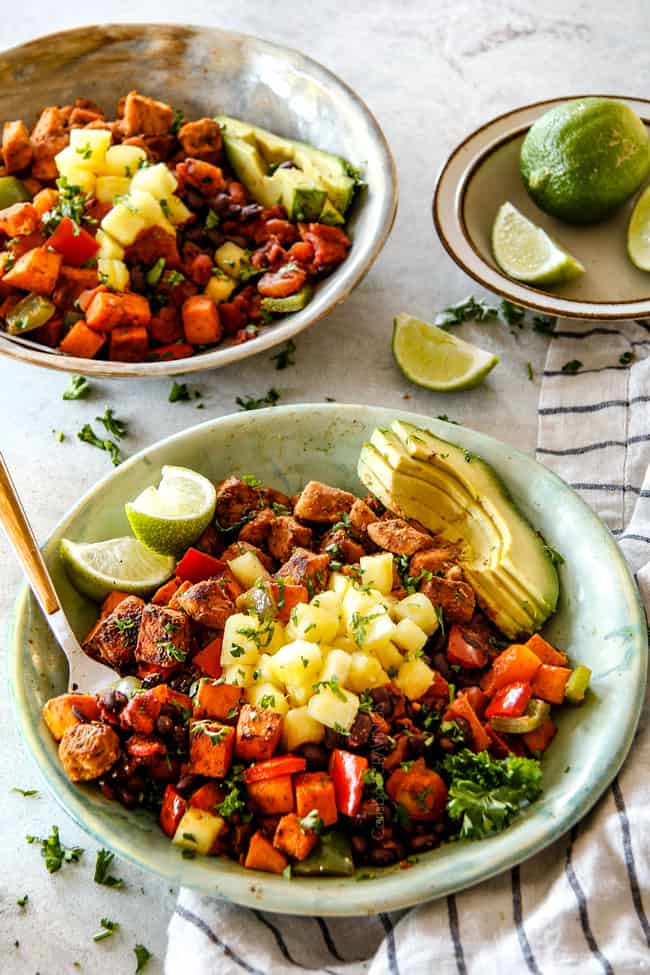 Two bowls of Cajun Chicken Black Bean Bowls with Avocado, Sweet Potatoes & Pineapple.