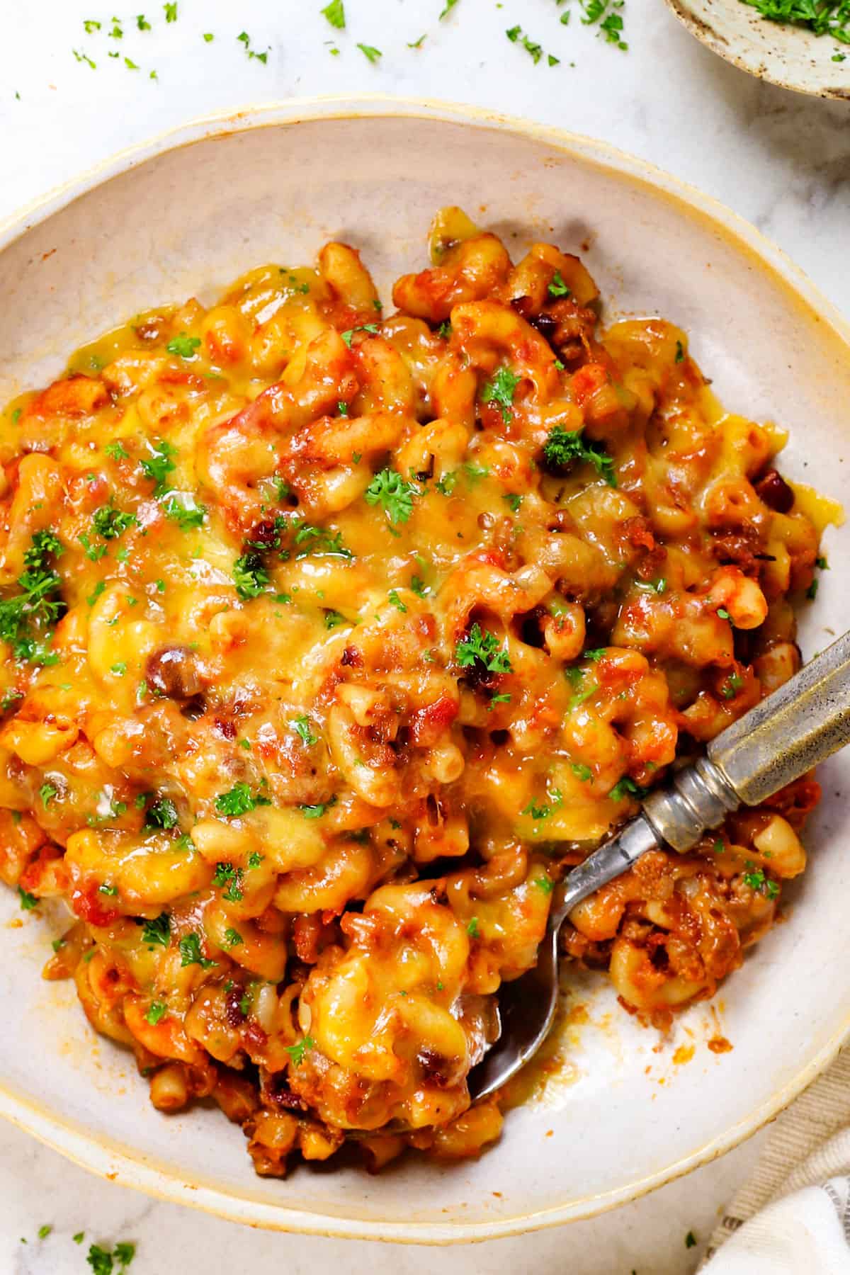 serving chili mac recipe on a plate topped with cheese