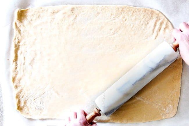 showing how to make pizza pinwheels by rolling out pizza dough