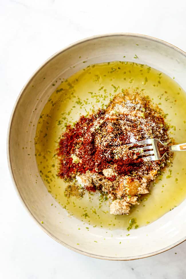 showing how  to make Chili Lime Chicken by whisking chili powder,  chipotle powder, garlic powder,  onion powder, brown sugar, lime juice and lime zest in a white bowl 