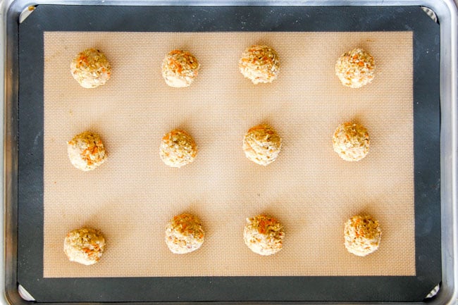 Showing How to make Carrot Cake Cookies by rolling cookie dough into balls on cookie sheet