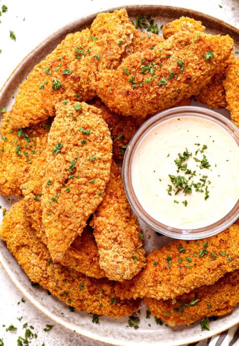 top view of serving oven baked fried chicken on a platter with dipping sauce