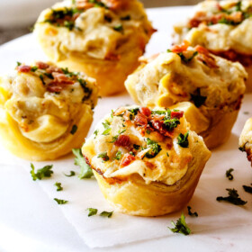 up close shot of Artichoke Dip Bites with parsley and bacon