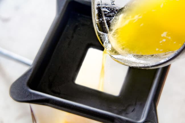  Zeigen, wie man Blender Hollandaise Sauce macht, indem man heiße geschmolzene Butter in die Oberseite des Mixers gießt, während er läuft