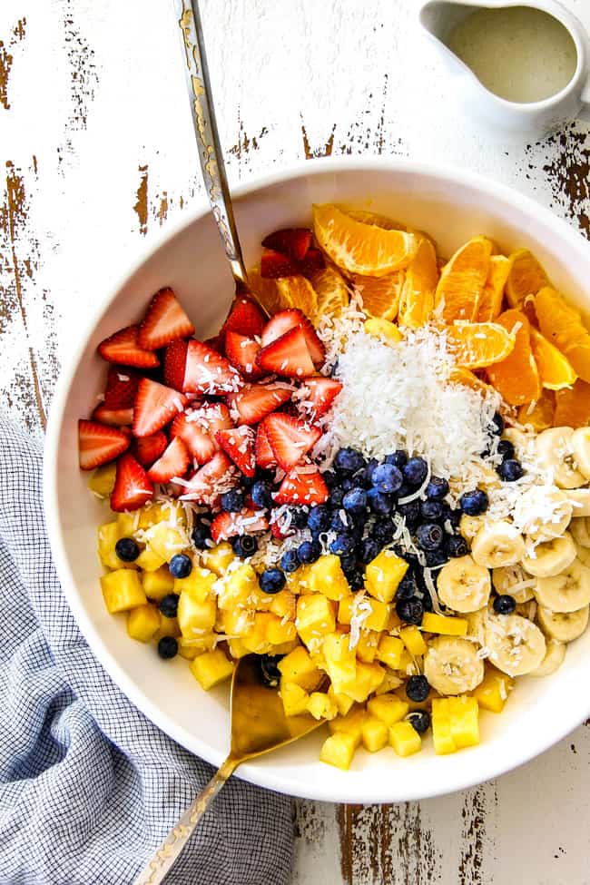 far away top shot of best Pina Colada Fruit Salad with pineapple, coconut, mandarin oranges, strawberries and blueberries in a white bowl
