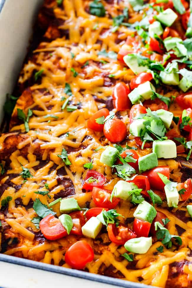 up close of cheesy Beef Enchiladas in a white baking dish