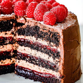 Chocolate Raspberry Cake with sliced removed showing layers of dark chocolate cake, raspberry jam filling, chocolate ganache and chocolate mousse