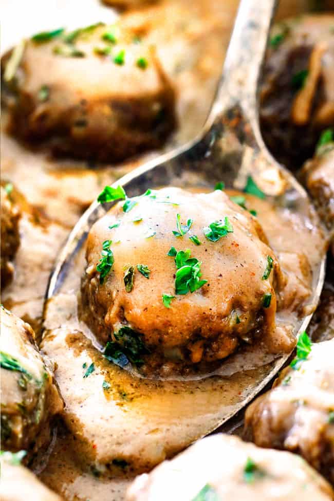 Up close of Swedish Meatballs on a spoon garnished with parsley with rich, creamy gravy