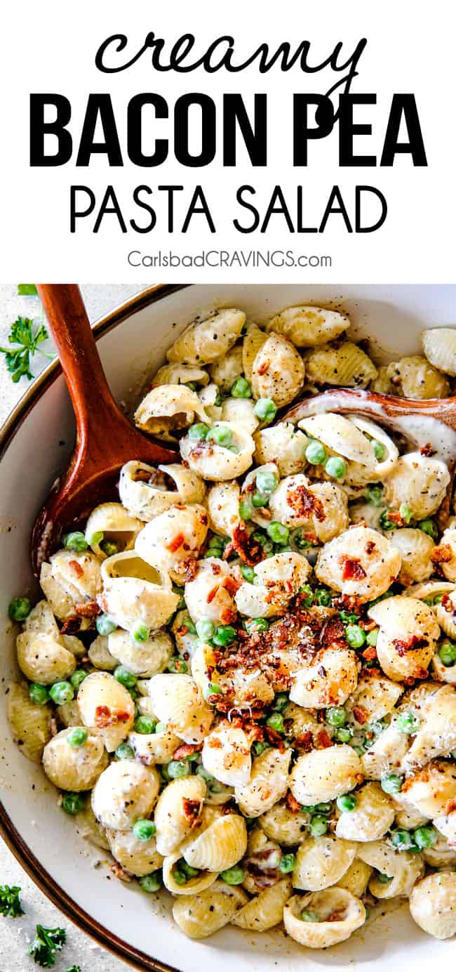 Top view of Creamy Pasta Salad with Peas and Bacon with a wood serving spoon