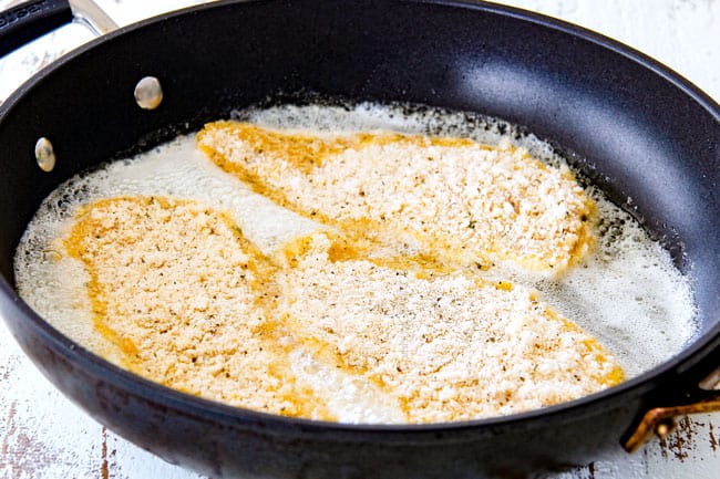 frying chicken Parmesan in butter and oil in a black skillet