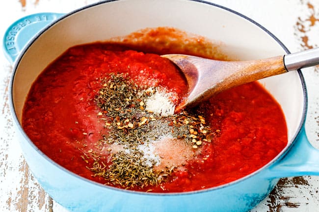 making homemade marinara for easy Chicken Parmesan with crushed tomatoes, basil, parsley, onion, garlic, thyme, oregano