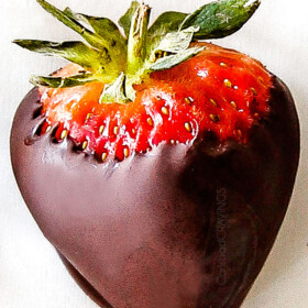 up close of chocolate covered strawberry on white parchment paper