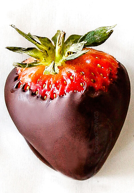 up close of chocolate covered strawberry on white parchment paper