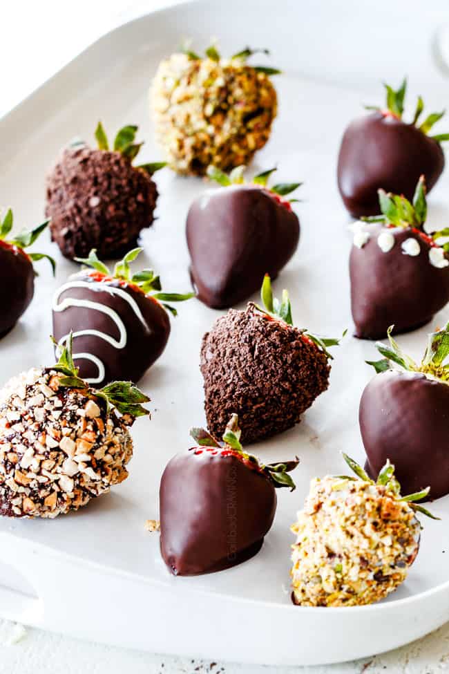 Chocolate dipped strawberries lined in a row on white parchment paper