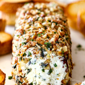 front shot of goat cheese log with garlic, zemon zest, basil, chives, parsley and rolled in pecans