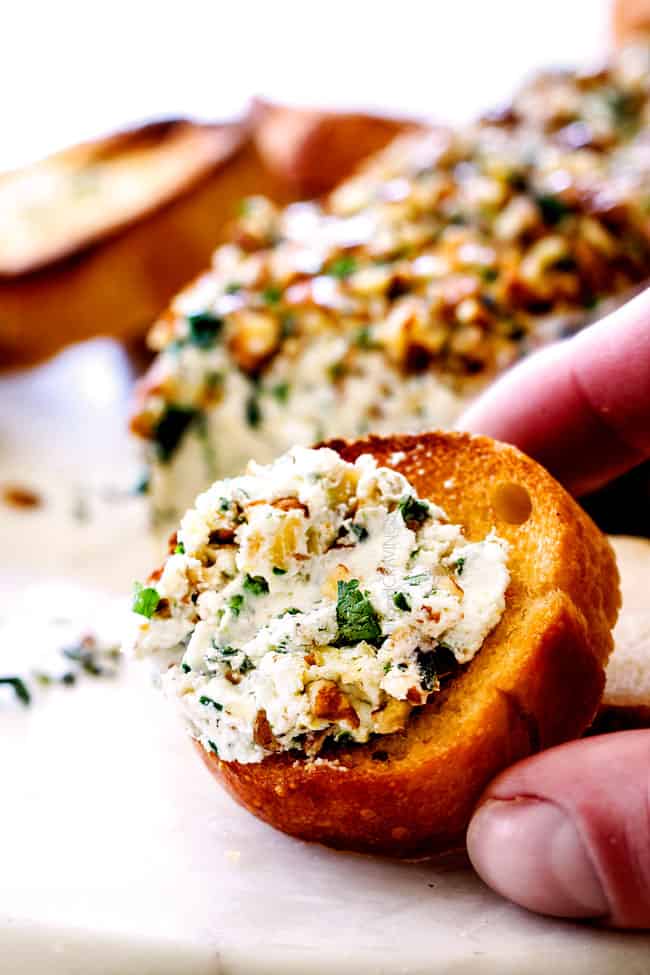 cheese log with garlic, lemon zest, basil, chives, parsley and rolled in pecans on a baguette