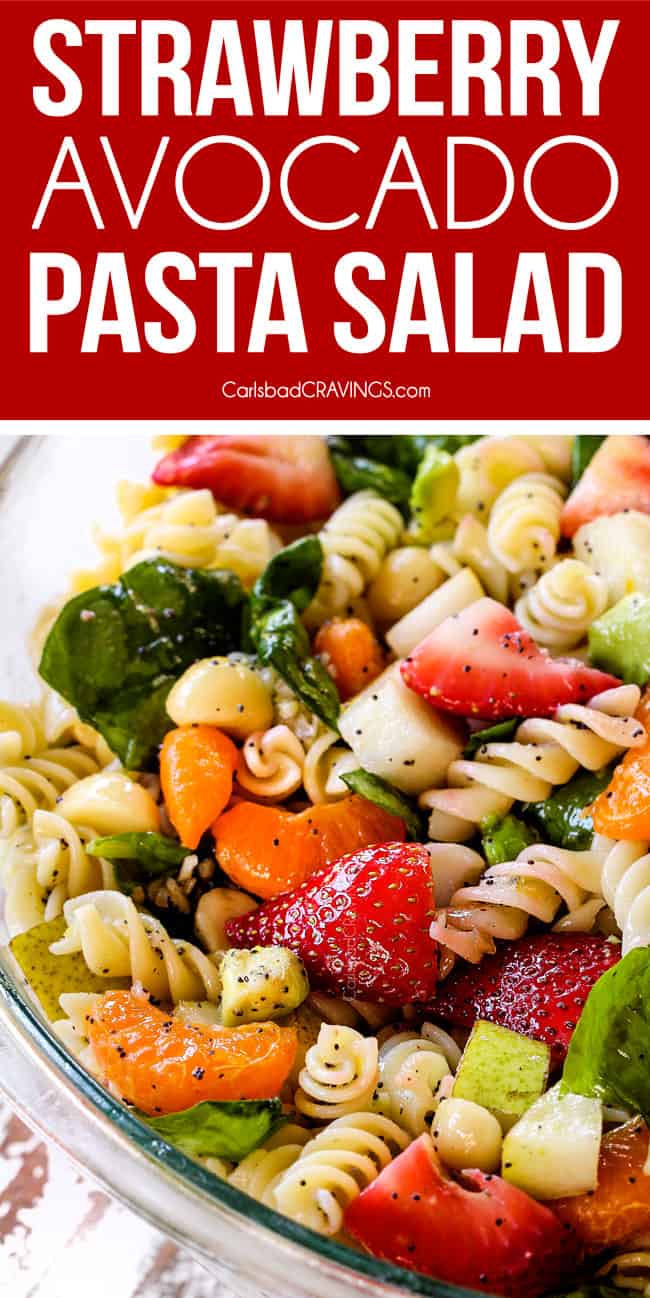 pasta, strawberries, spinach, Mandarin oranges, avocados, macadamia nuts in a glass bowl with poppy seed dressing mixed together for pasta salad