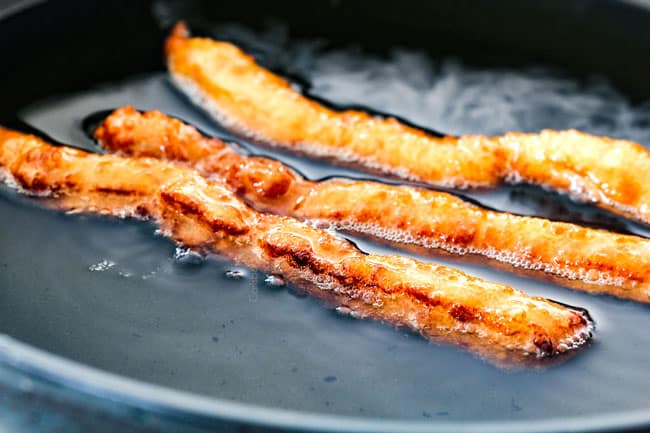 frying three churros in vegetable oil in a black deep sided skillet showing how to make churros