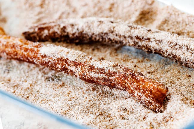 rolling homemade churros in cinnamon and sugar Showing how to make churros